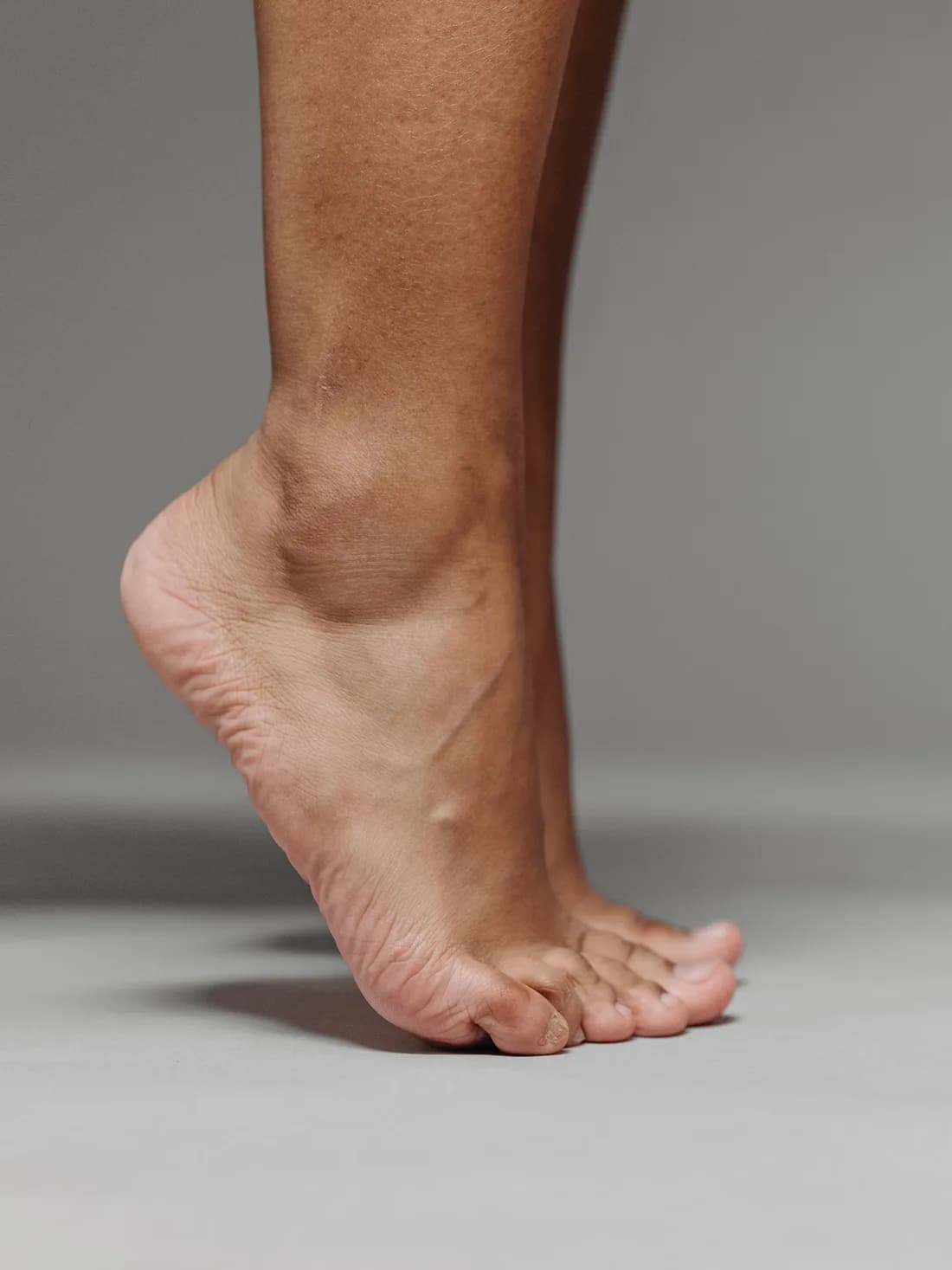 발뒤꿈치를 든 맨발의 근접 사진.