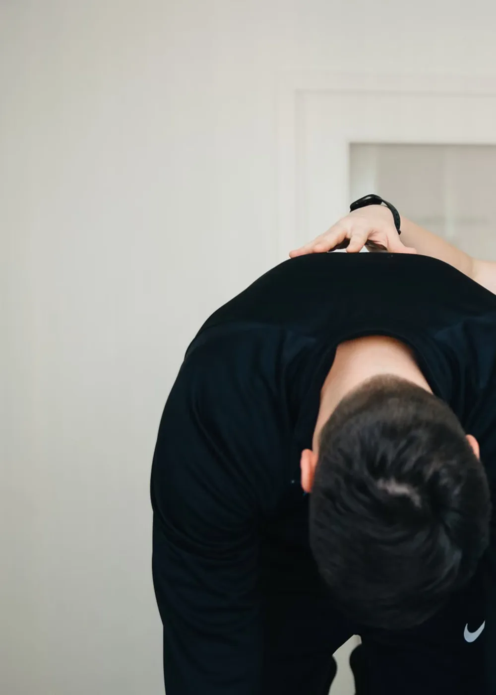 몸을 앞으로 숙인 사람의 등에 손을 얹고 확인하는 근접 장면.